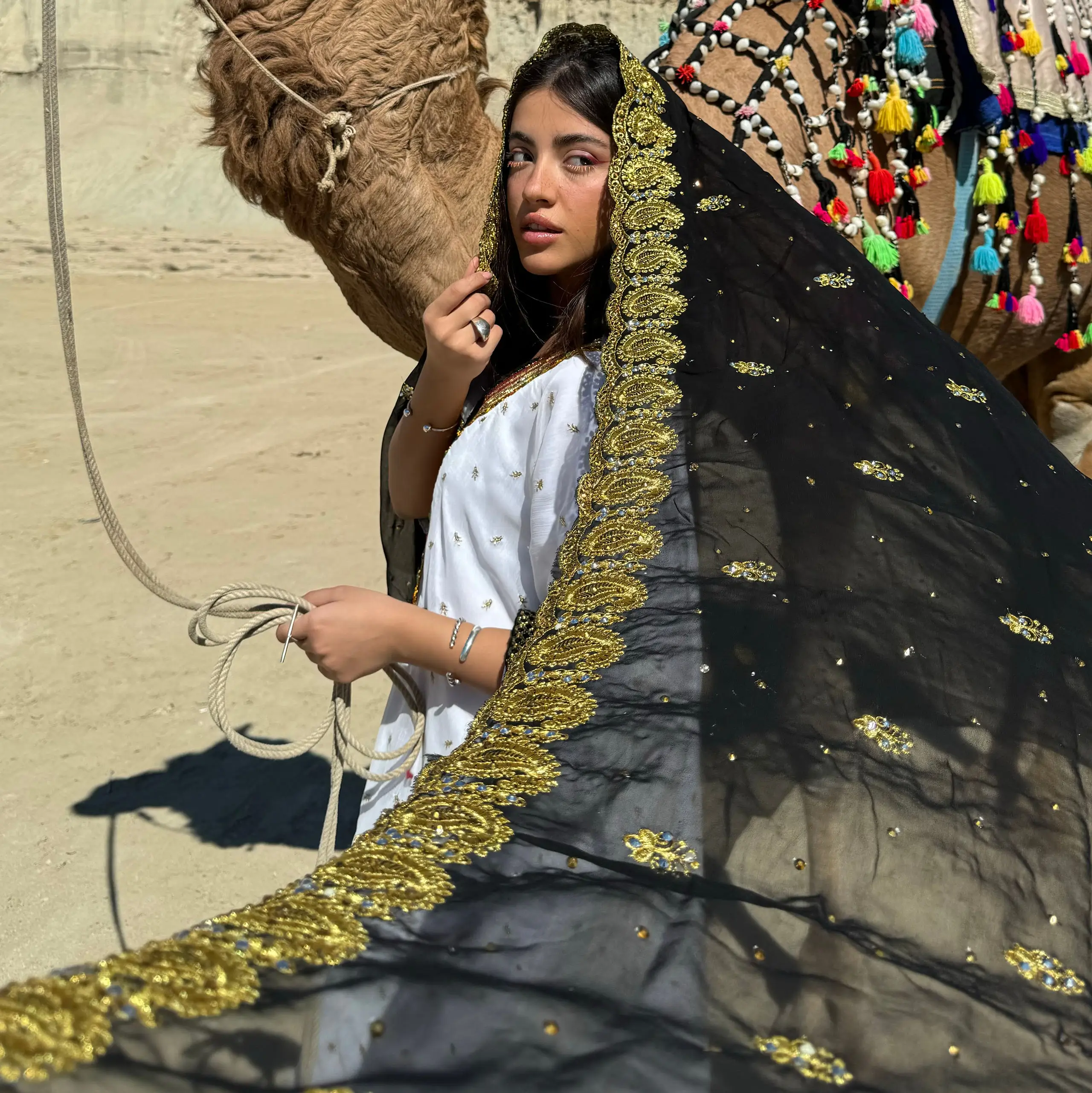 دختر بندری با شال اُرنی مشکی حاشیه گلابتون طلایی و نگیندوزی، استایل سنتی جنوب با شتر در کویر هرمزگان